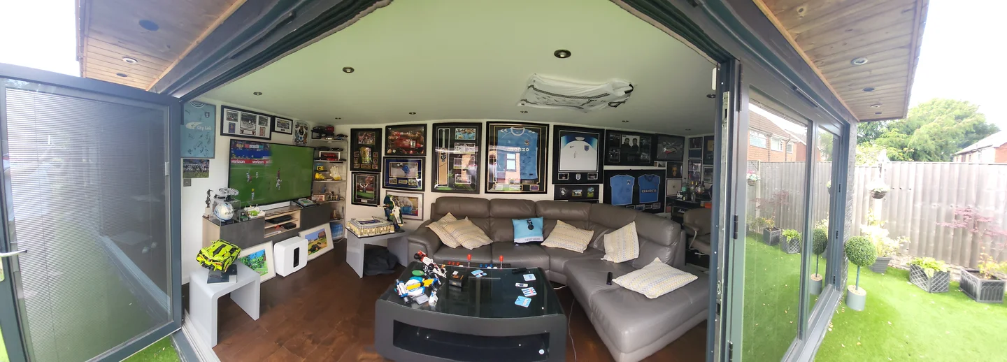 Panoramic view inside Kevin Burdett's Crown Pavilions garden room, from the TV corner to the garden beyond the bi-fold doors